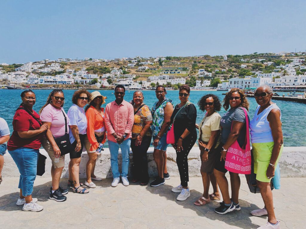 Group people posing for photo with a Mykonos town backdrop