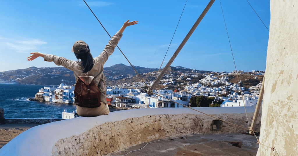 Girl seating on the wind mill in Mykonos