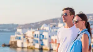 Couple standing with Mykonos Little Venice in the background.